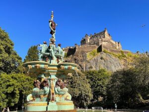The Ross Fountain shines in the blue sky with Edinburgh Castle in the background