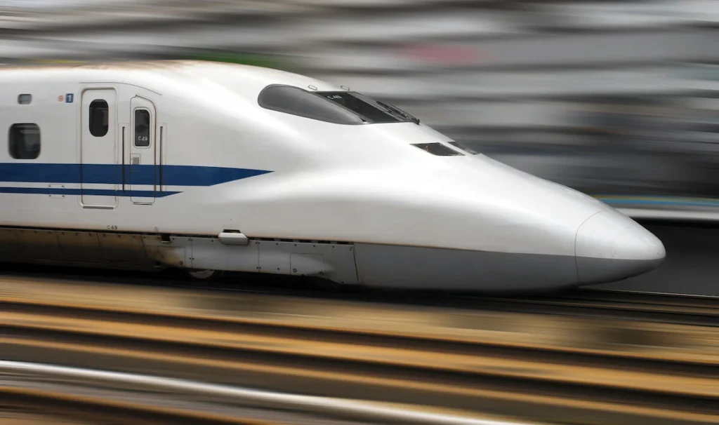 A white bullet train stands out as the track blurs at speed