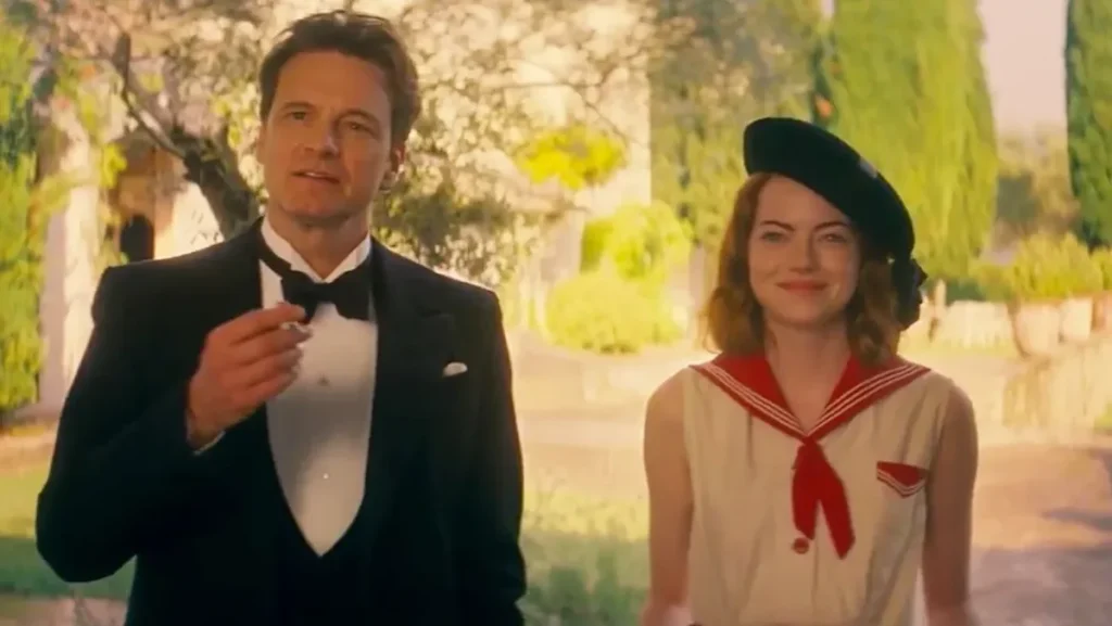 Colin Firth in a Tuxedo and Emma Stone in a french Beret walk through a bright South of France garden