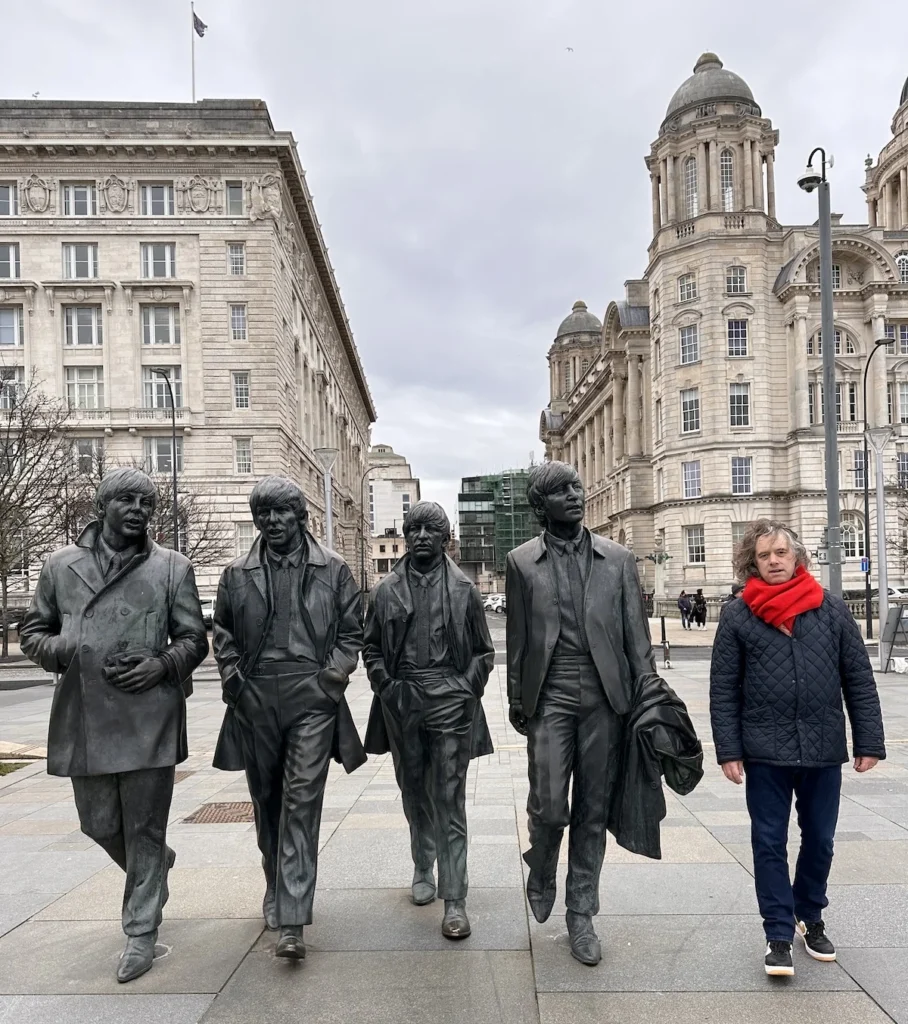 The 'Fab Four' Beatles statue with a 6ft human (the author) dressed in jeans and a red jacket to show the scale and size of the statue.