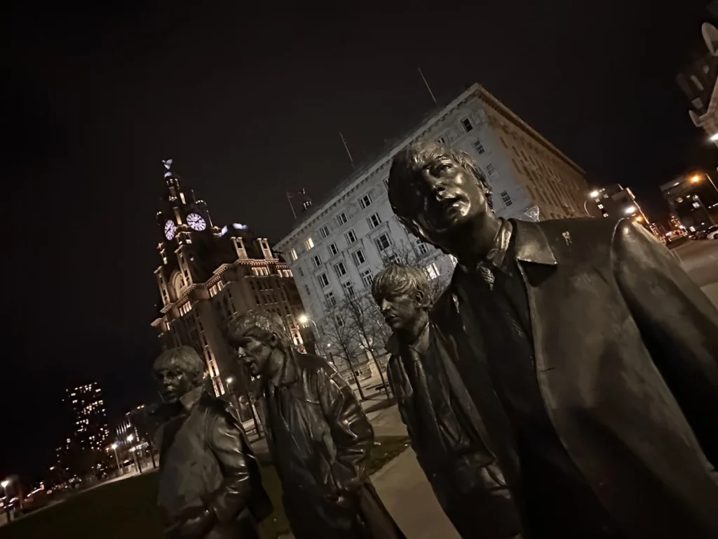 The Beatles at Night, the statue lit by ambient light around Pier Head with the iconic clock tower of the Liver Building in the background.