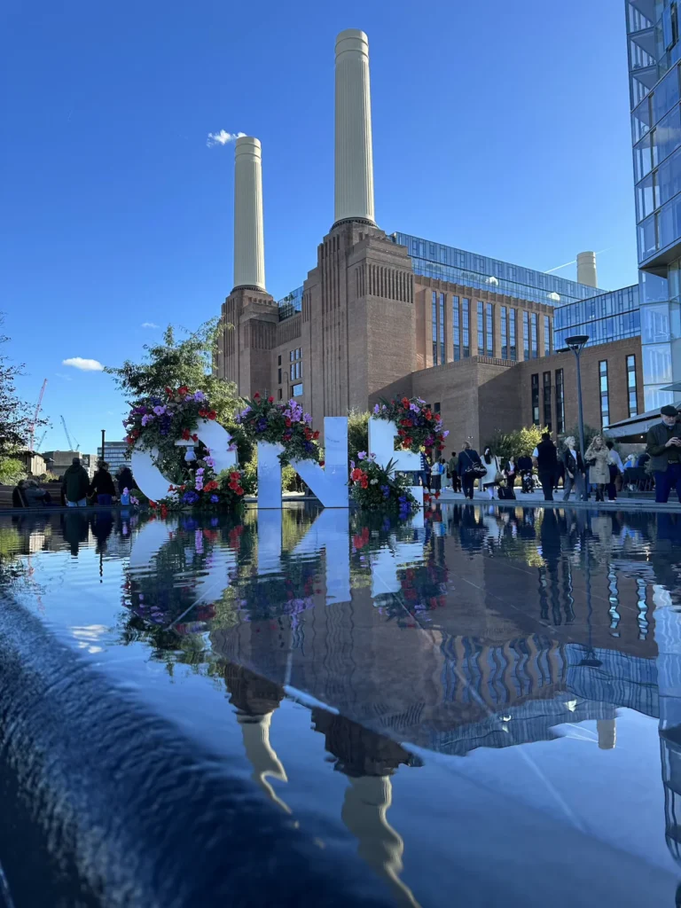 The famous chimneys of the Battersea Power Station stand proudly against the blue sky 