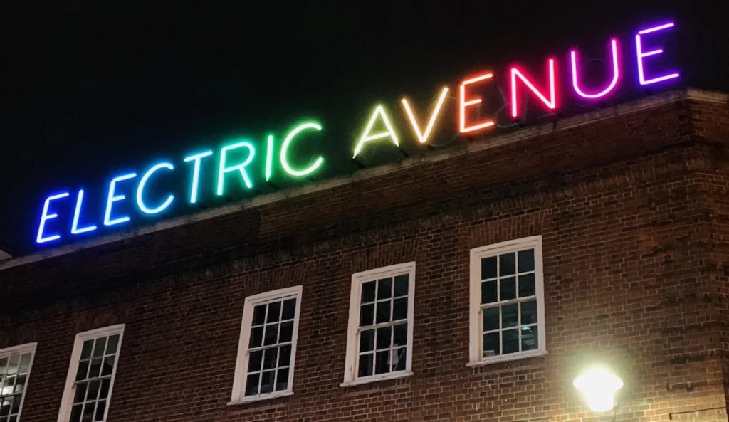 The Multicoloured sign for Electric Avenue, lit up at night
