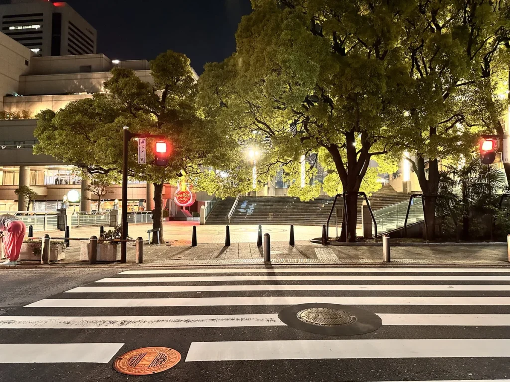 A cross walk looking towards Hard Rock cafe at night in Yokohama Japan