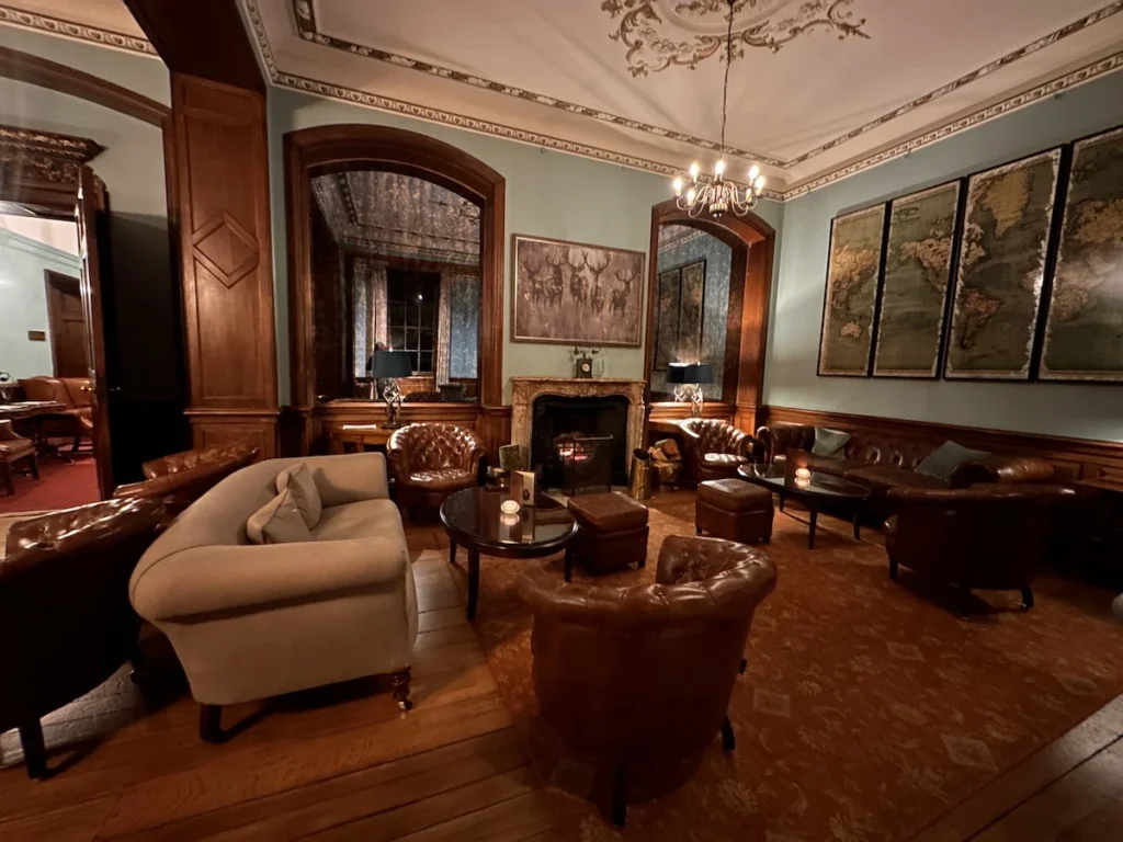 Leather sofas and chairs are in the blue walled library of the Hawkstone Hall Hotel 