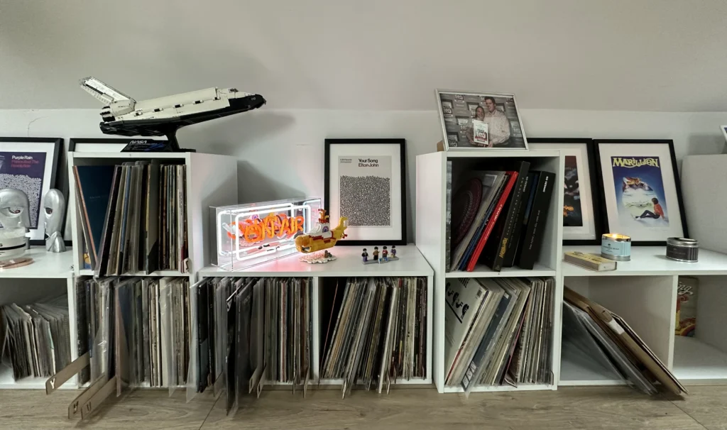 Messy record shelves with vinyl, Beatles lego, rock art prints and more