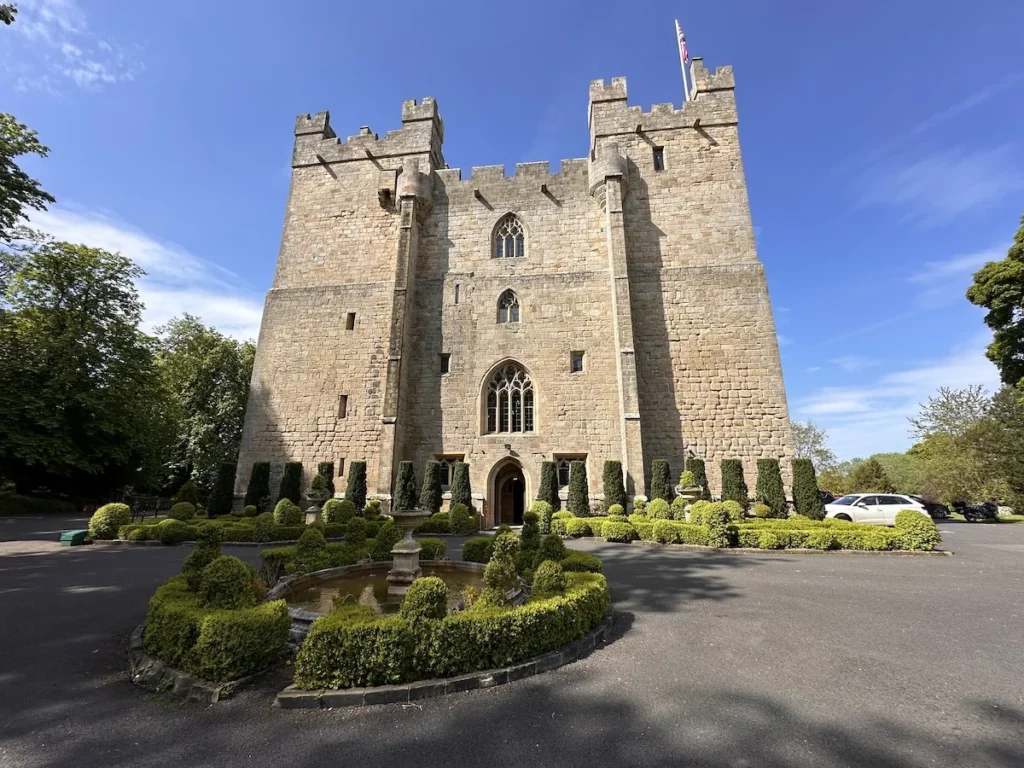 The yellowing stone of Langley Castle stands out against the bright blue sky 