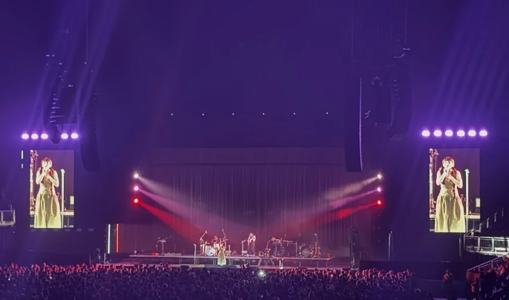 Lauren Mayberry bathed in purple and red lights on stage at London's O2 Arena