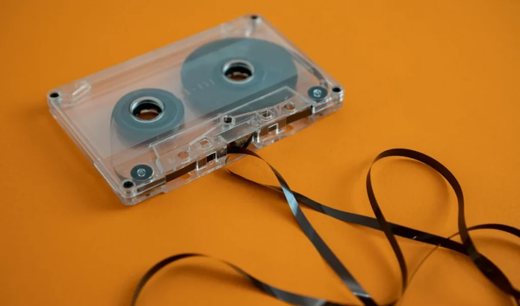 A transparent cassette with tape streaming out from the bottom