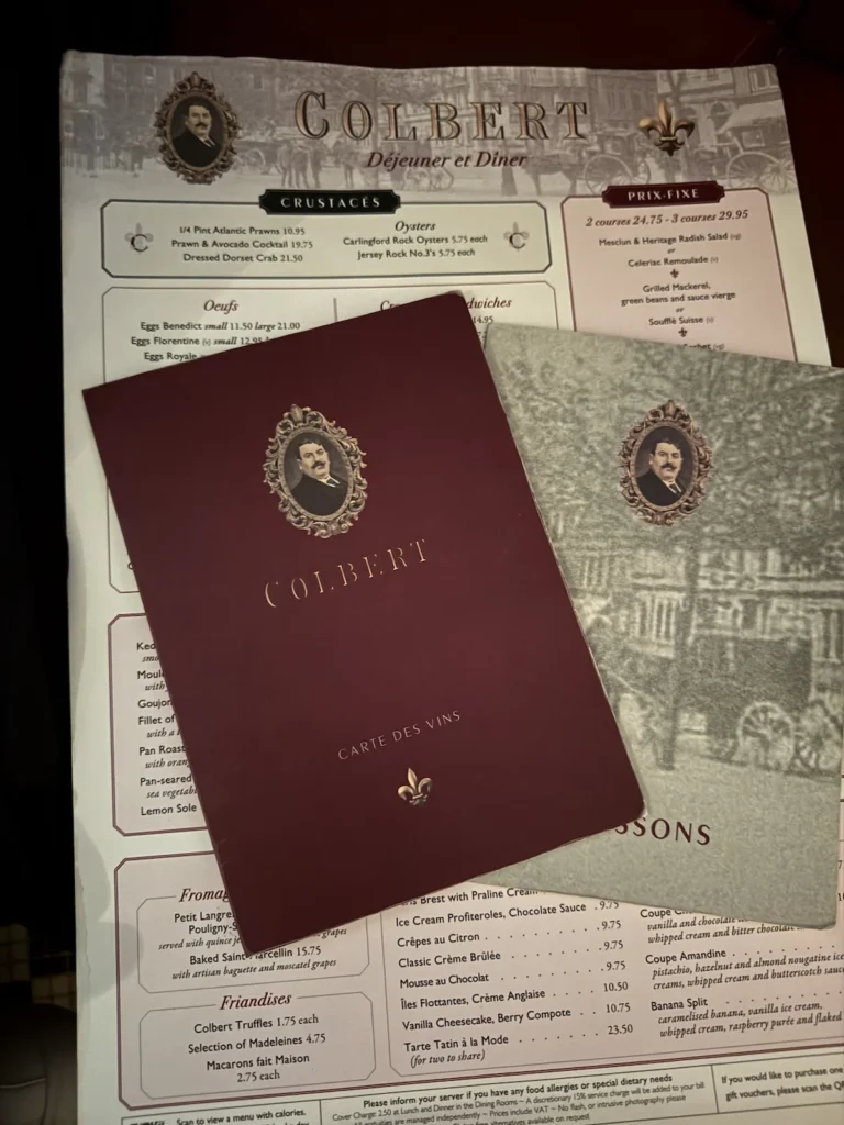 The main Colbert Menu sits beneath the smaller dark red Colbert Wine Menu and Grey 'Boisson' Meu at Colbert Sloane Street Restaurant