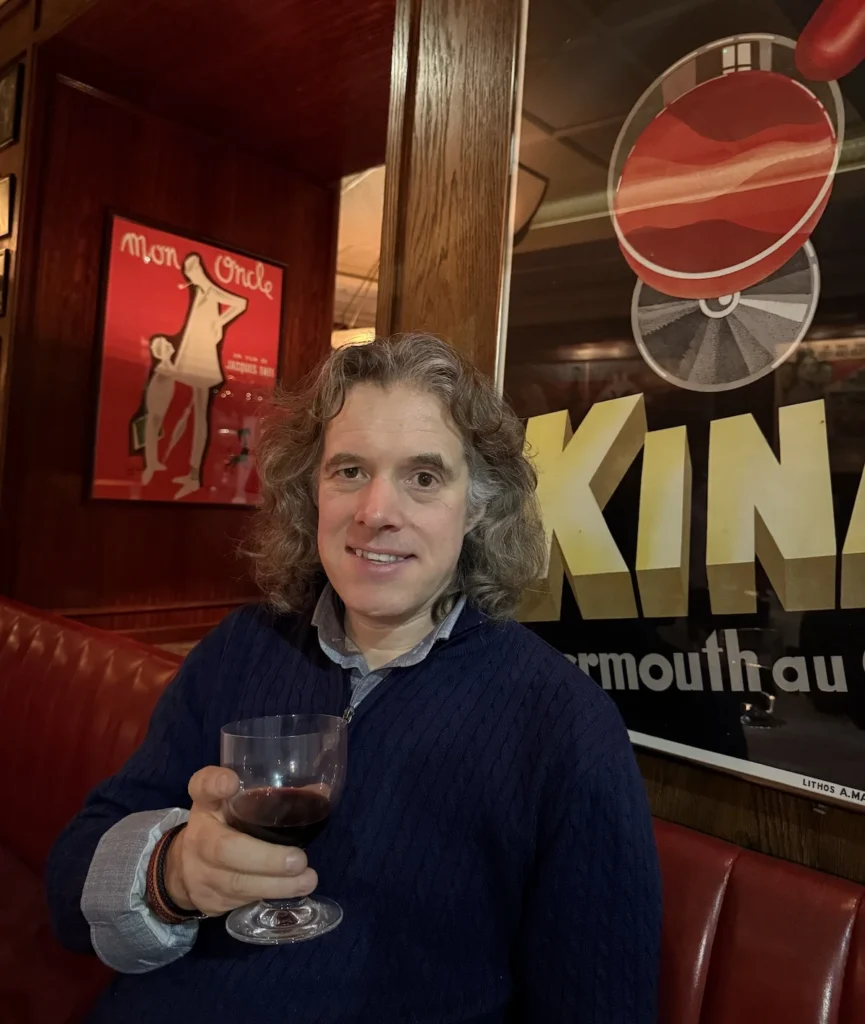 Jay Riddell holds a glass of red wine at one of his favourite restaurants of 2024