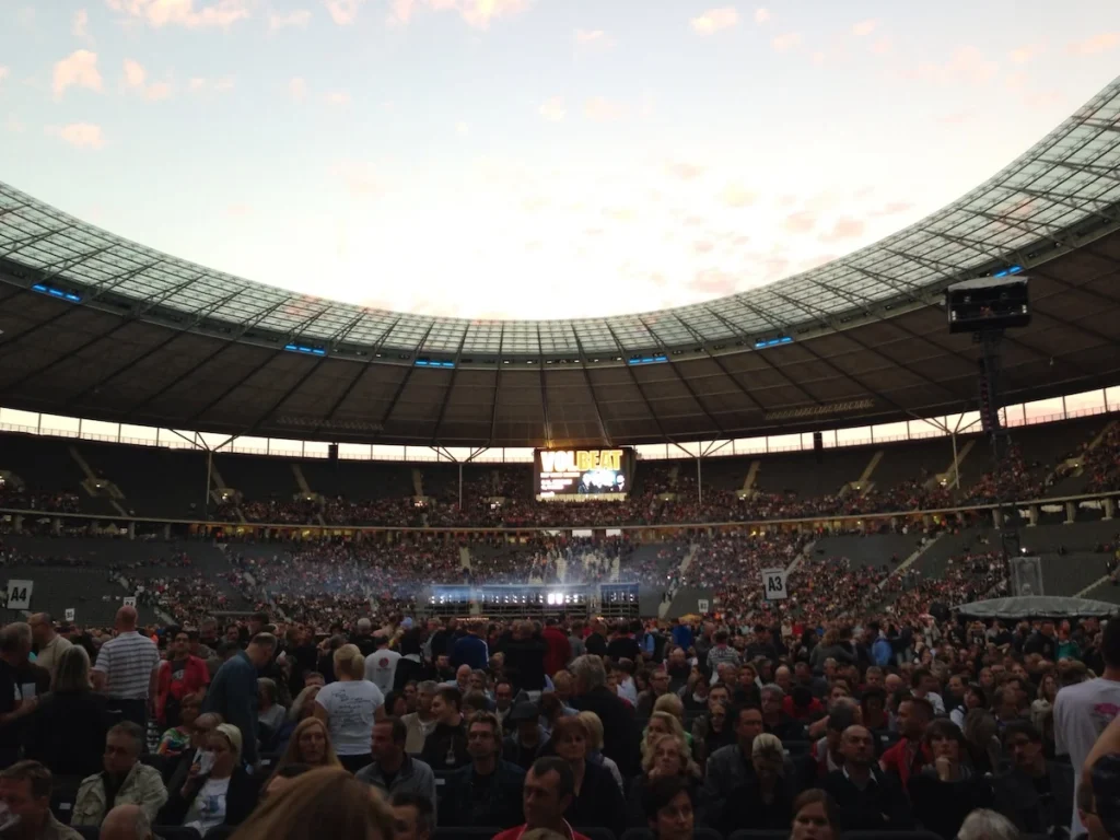 A full crowd at Berlin's Olympic Stadium under the curved roof and darkening sky for a Roger Waters concert