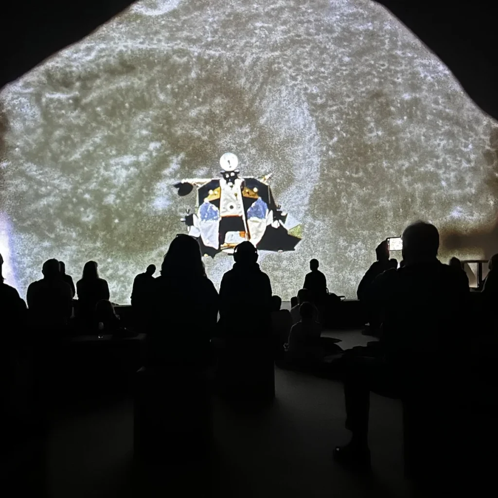 An overhead photograph of a lunar lander heading to the moon surface. A real image that looks like a movie when projected on the Lightroom screen