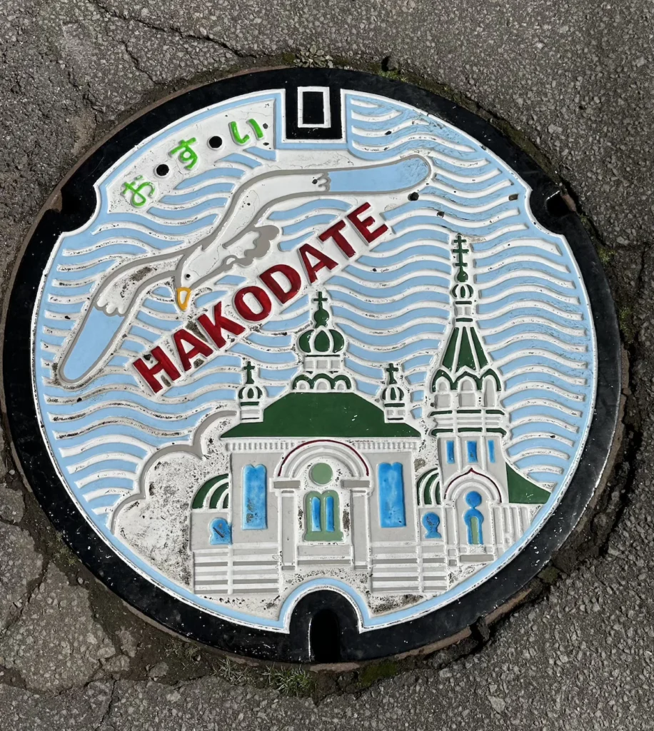 A decorative manhole cover in Hakodate, Japan, featuring intricate artwork unique to the region