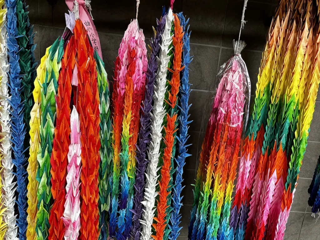 Colourful origami cranes folded as symbols of peace, strung together at Nagasaki Peace Park in remembrance of atomic bomb victims.