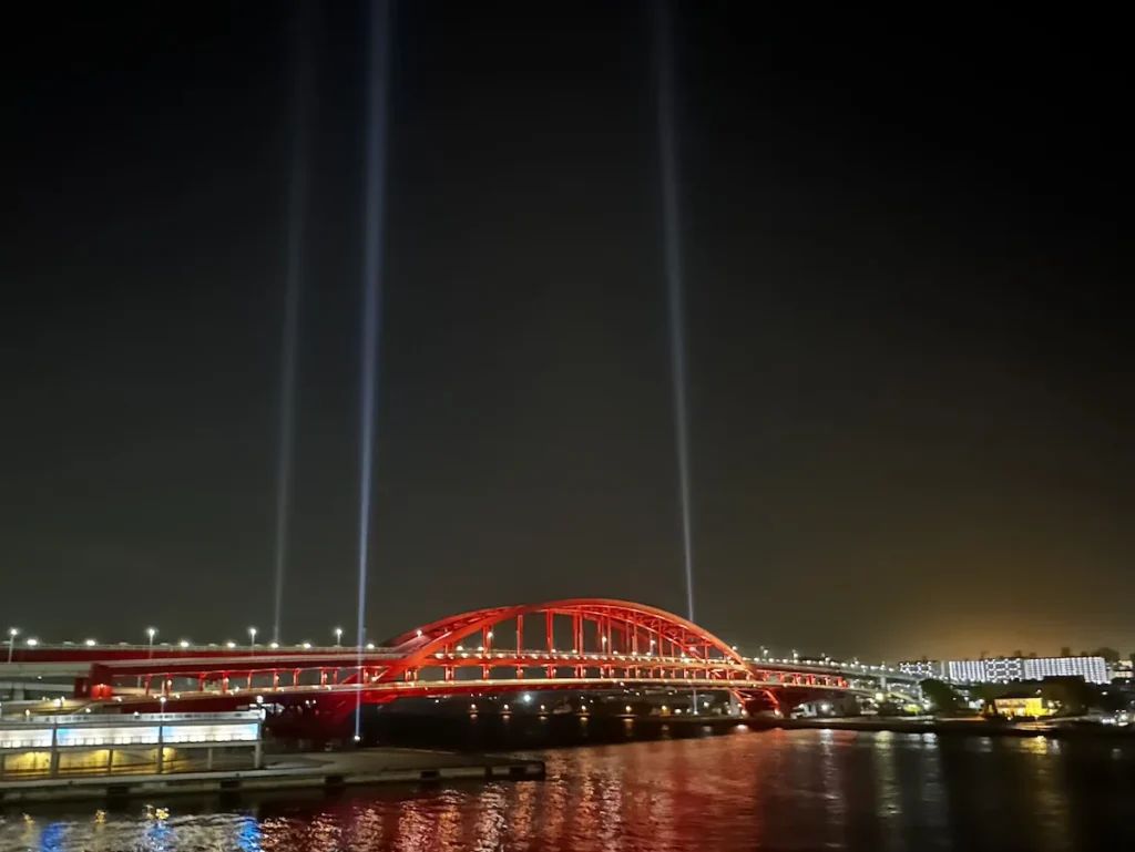 The Ohashi Bridge in Kobe spans the port, its towering steel framework standing against the cloudy sky. A key transportation link, the bridge connects the city’s bustling port district, emphasizing Kobe’s role as a gateway to global trade. © Wine Travel and Song.