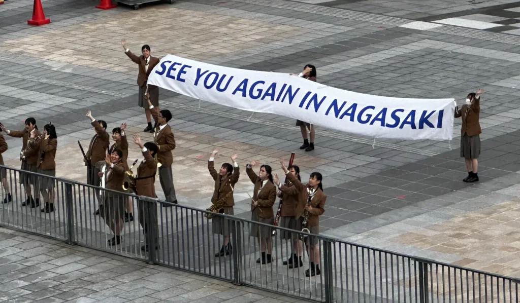 Nagasaki departure ceremony with locals waving farewell as the cruise ship sets sail ©Wine, Travel & Song