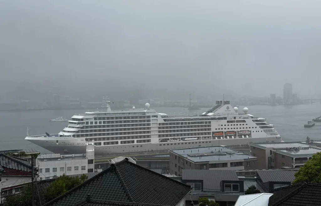 Looking down from the hills around Nagasaki to see the Silver Muse in port, set against the grey backdrop of a rainy day 